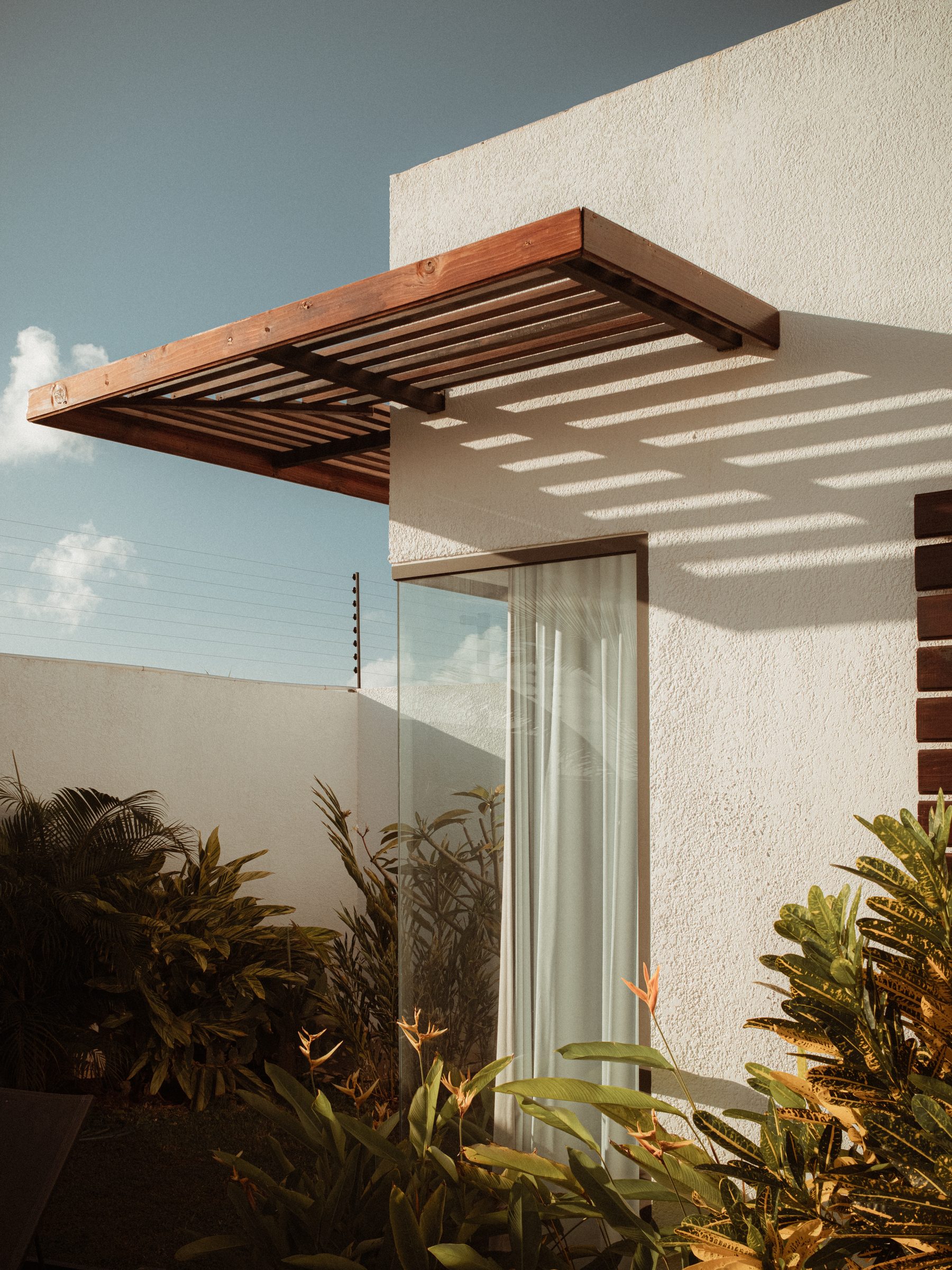 Timber pergola casting shadows on a white wall