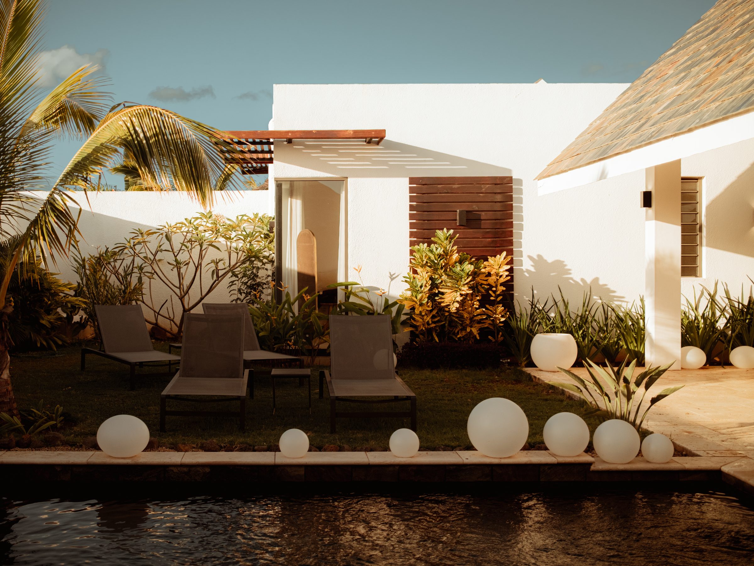 Garden, pool and white walls in late sun