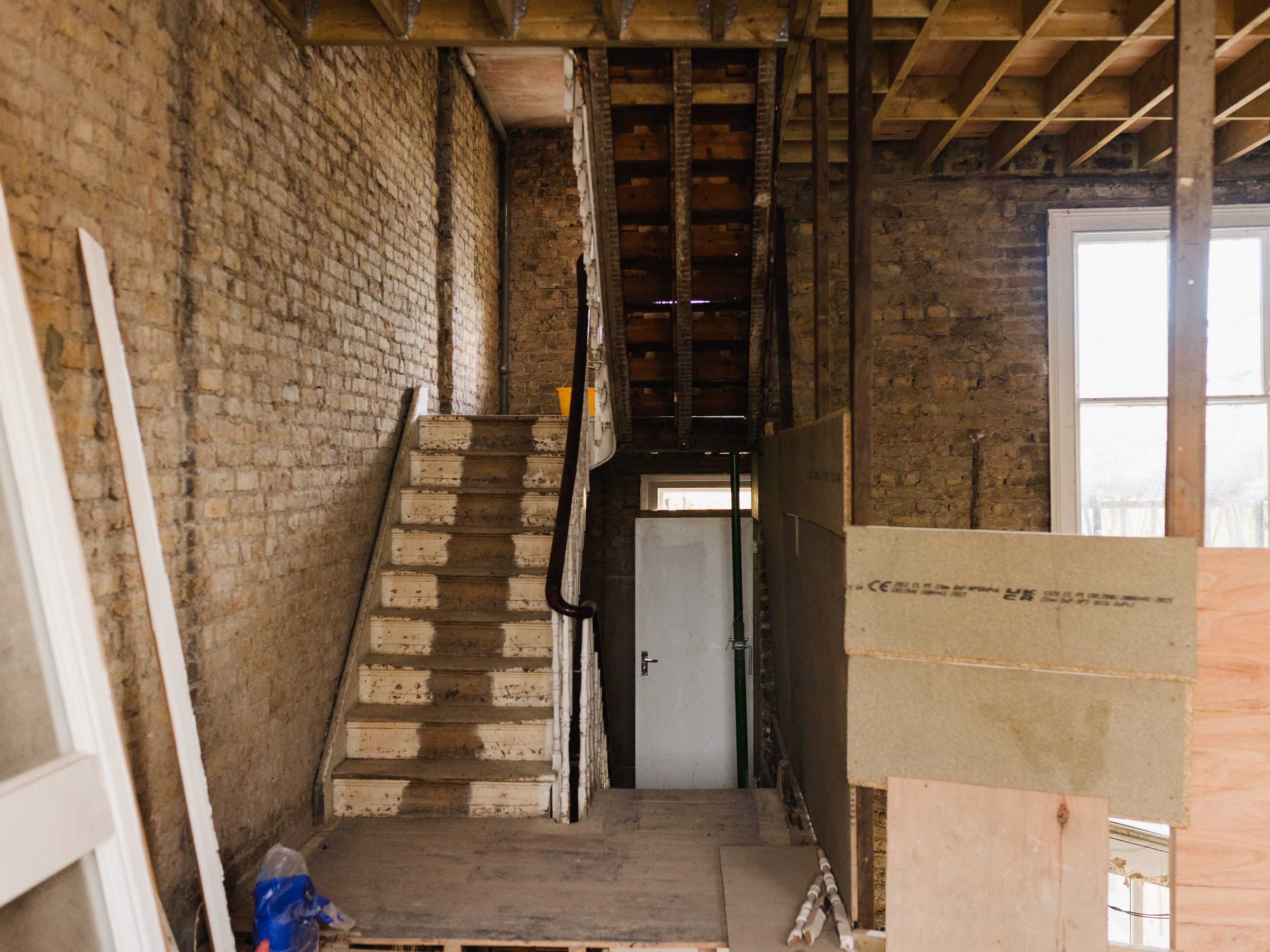 Stripped-back stairwell and hallway mid-renovation