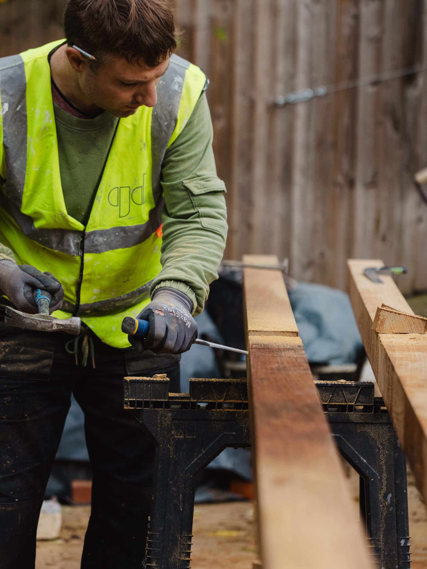 Graff team member cutting timber on site